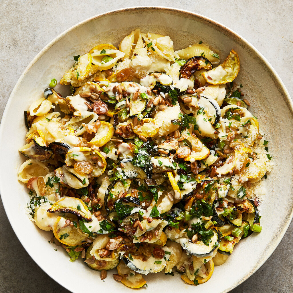Pasta with mushrooms and zucchini in a white bowl.