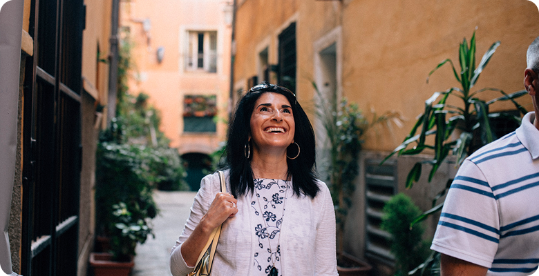 Smiling solo traveler walking a sunlit European street on France for Solo Travelers: Paris, Provence & the Riviera — opens itinerary