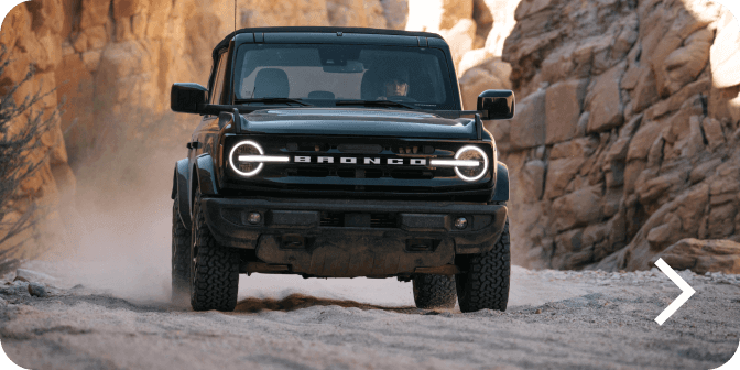 A Bronco&reg; SUV Outer Banks&reg; model being driven off‑road in a desert landscape