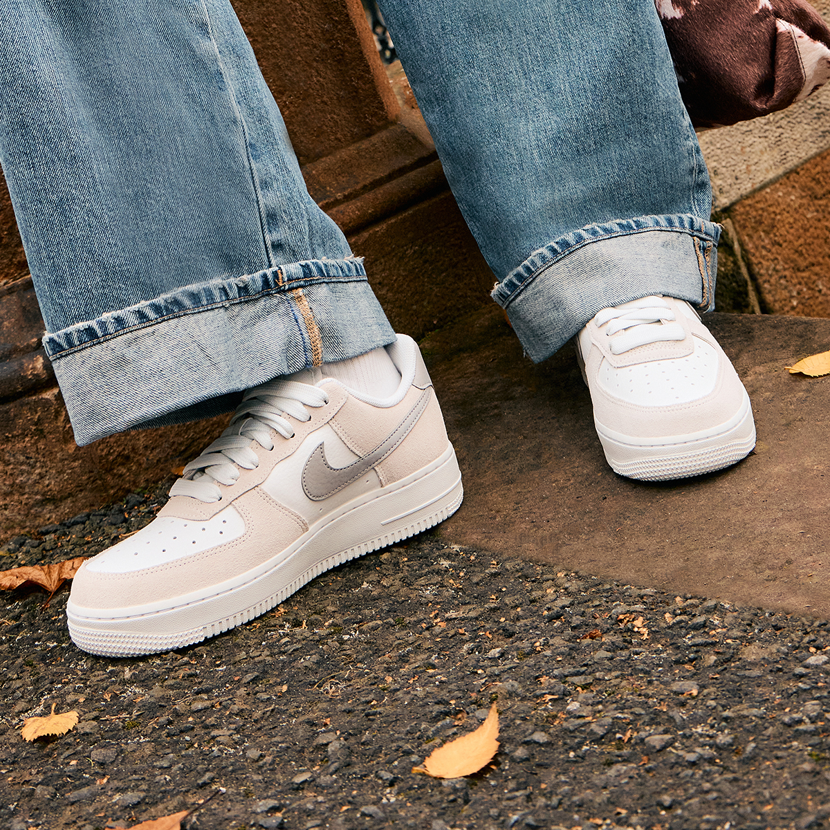 An image of a person's lower legs wearing beige Nike trainers