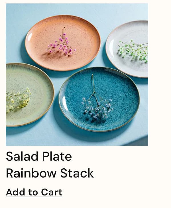 Four colorful salad plates with small flowers on top, arranged on a light blue table.