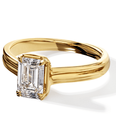A yellow gold diamond solitaire ring with an emerald cut center stone.