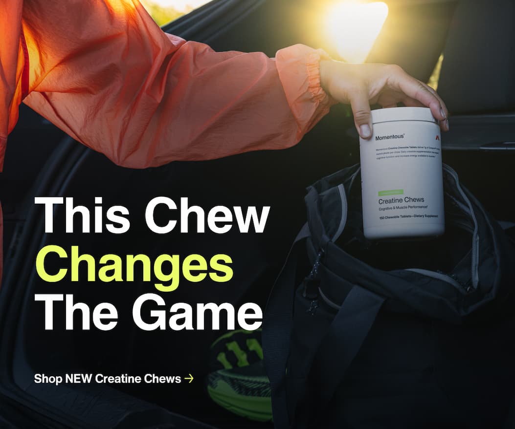 Person wearing an orange jacket placing a container of Momentous Creatine Chews into a gym bag with text overlay reading 'This Chew Changes The Game' and 'Learn More About The Innovation Behind Creatine Chews'.