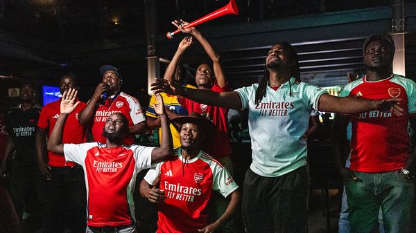Kenyan fans of Arsenal FC react while watching a match on television in Nairobi, Kenya