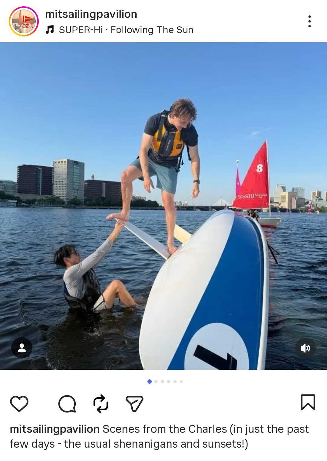 Two students in water hang and stand on keel at the underside of a sailboat. Text via @‌mitsailingpavilion: Scenes from the Charles (in just the past few days - the usual shenanigans and sunsets!)
