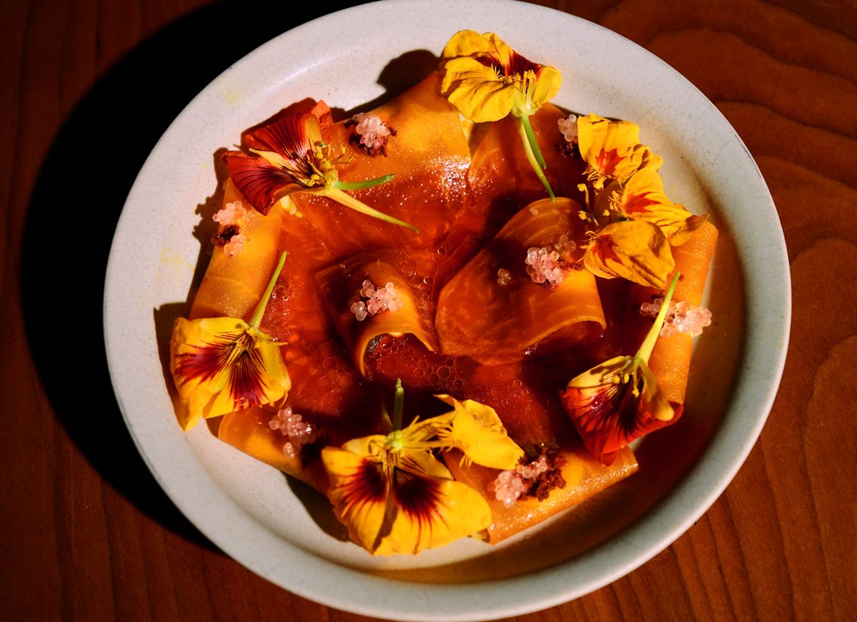 Sliced yellow beets plated with yellow flowers.