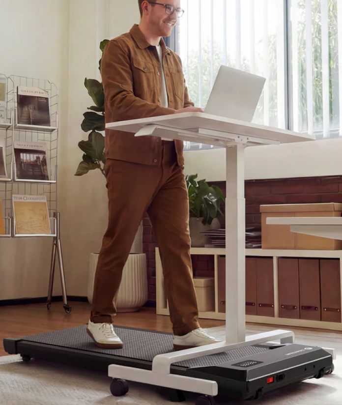 Man walking on a DeerRun Walking Pad while working at a standing desk