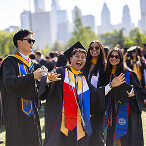 Students celebrating in graduation robes.