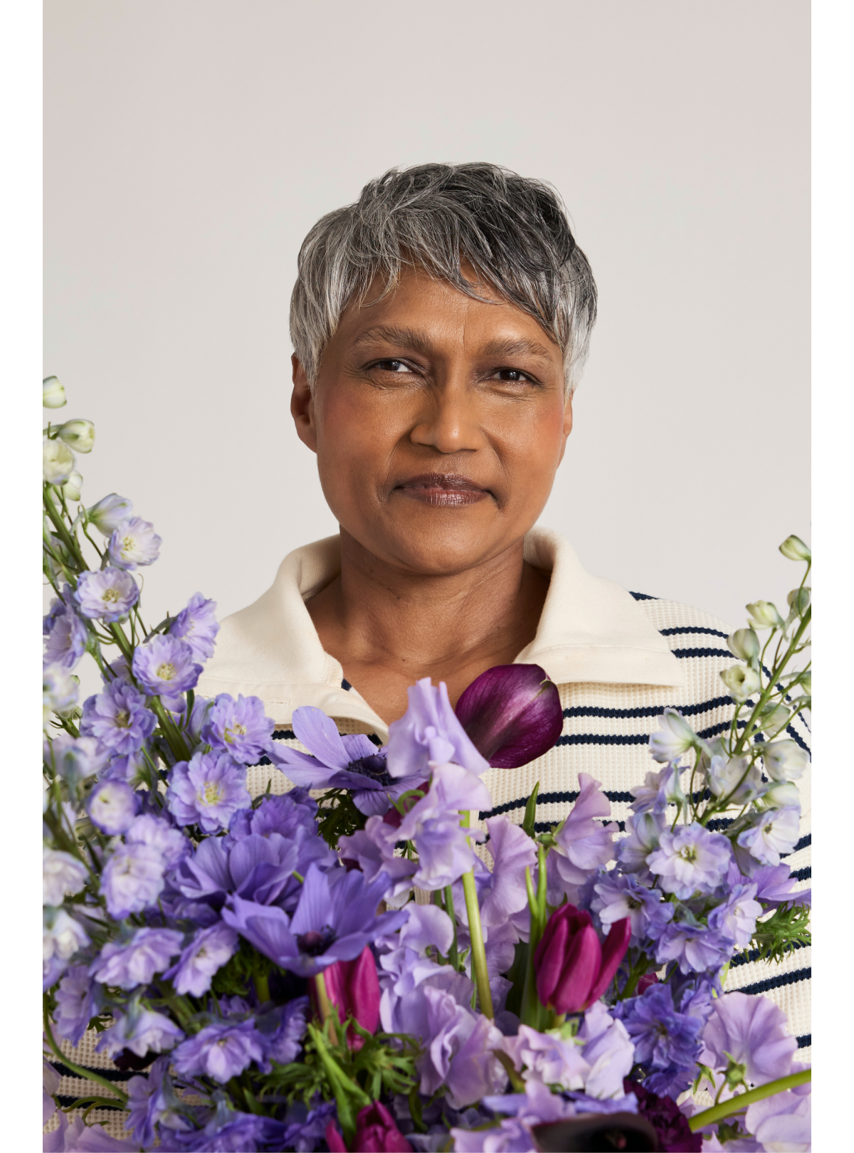 Model wearing the Waffle Knit Pullover in Sailor holding a beautiful floral arrangement.