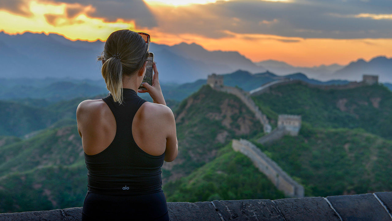 A tourist takes photos of clouds at sunset over the Jinshanling section of the Great Wall in Chengde, China, on June 1st 2024