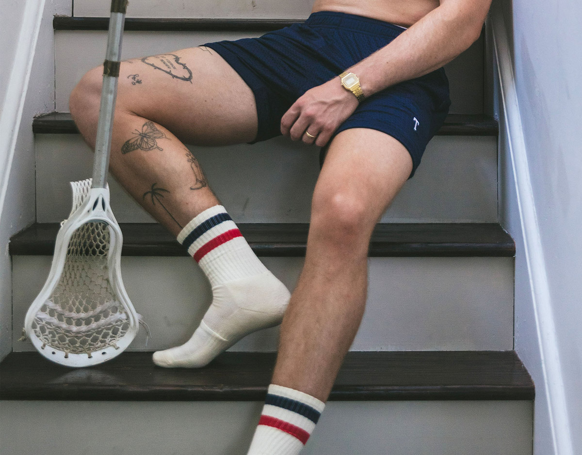 Man wearing lounge shorts and tech varsity socks on steps.