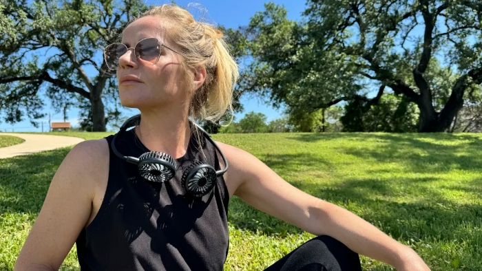 Underscored writer wearing portable neck fan
