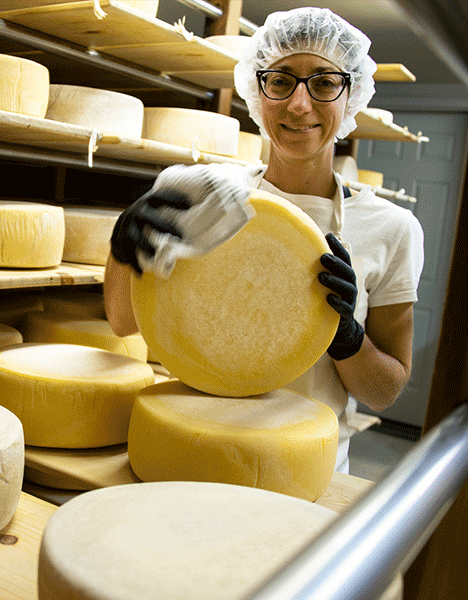 a woman holding a piece of cheese