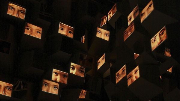 General view of  'En Tus Sentidos' by the artist artist Willy Sousa. lots of images of faces are shown. 