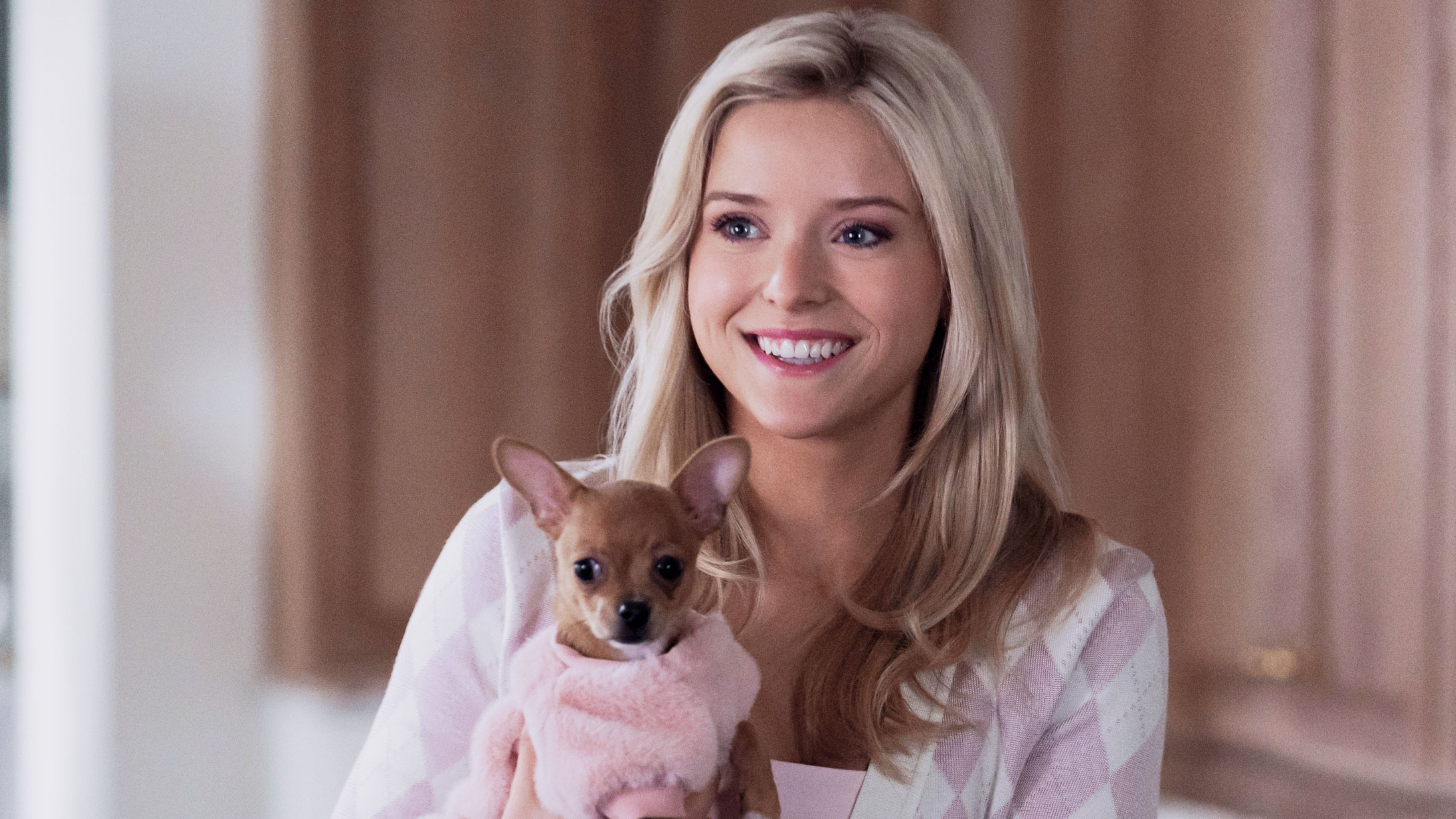 A woman holds a dog.