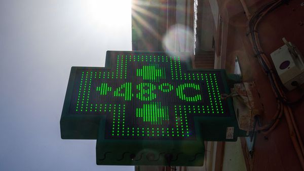 This photograph shows a pharmacy sign displaying the temperature of 48 degrees celsius in Toulouse
