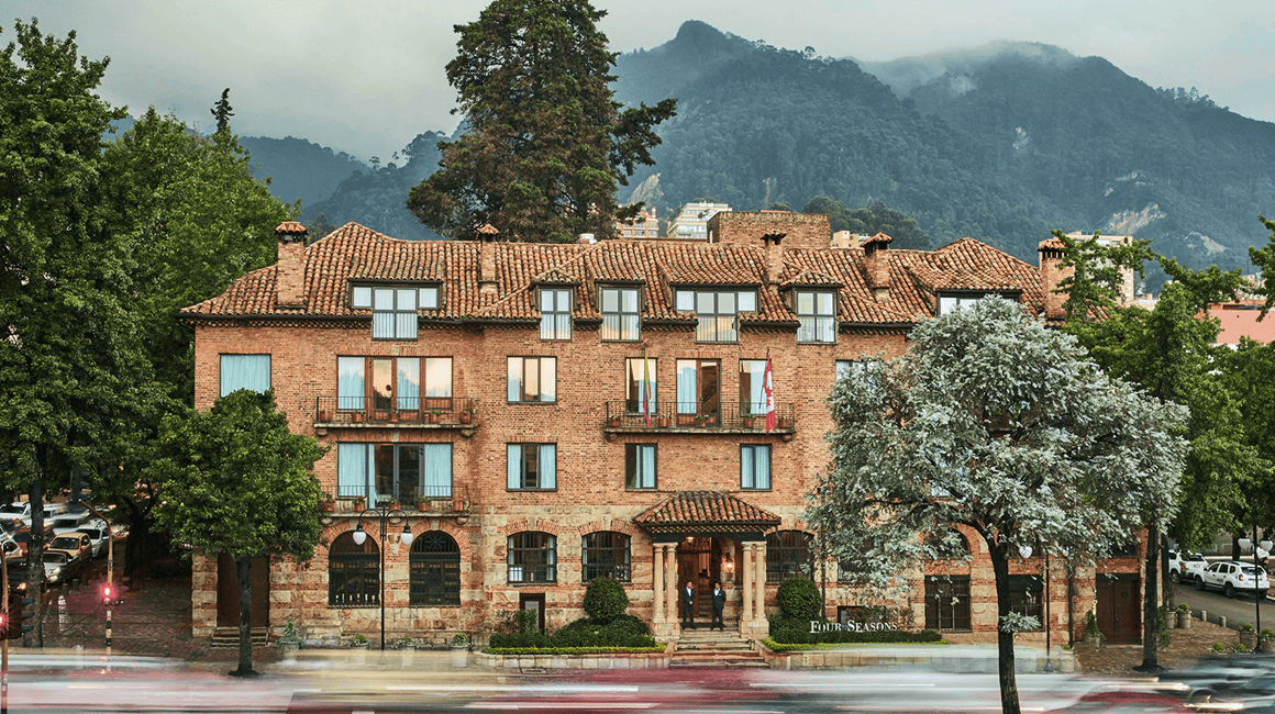 A stately red-brick hotel set against mountains.