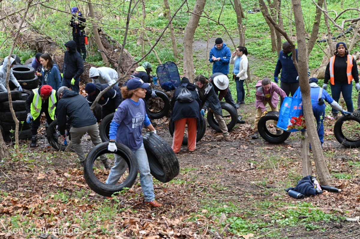 Volunteers forming a chain to remove tires during a United By Blue clean-up in Philadelphia