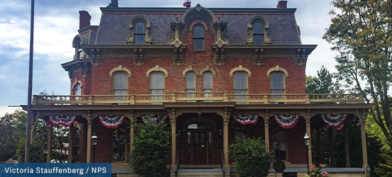 An outside view of the historic National First Ladies Library & Museum; a house with a large, covered front porch, decorative dormers and many more Victorian features 