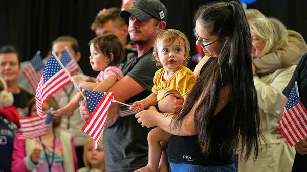 Afrikaner refugees from South Africa holding American flags arrive at Dulles International Airport, United States.