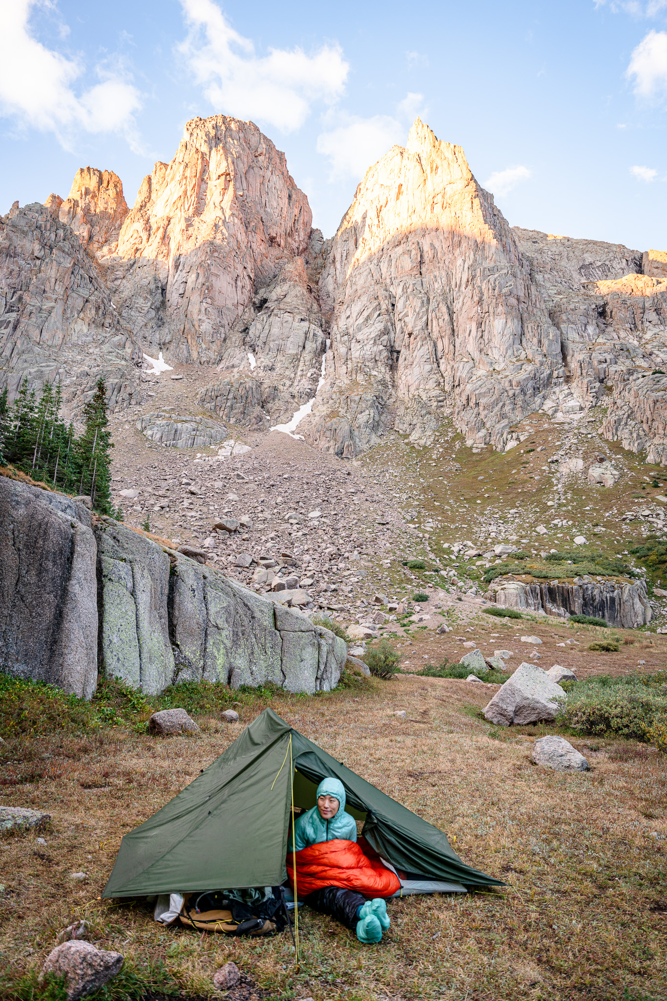 Girl sitting in tent with mountain behind them