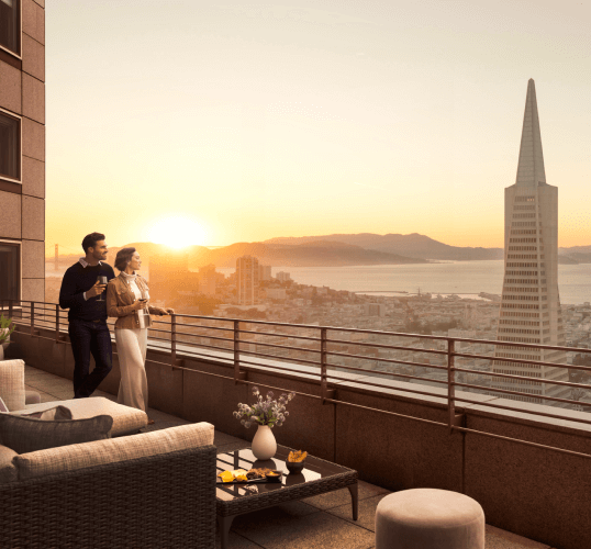 Room view of a cityscape with iconic tower and ocean backdrop.