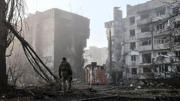 A soldier surveys damaged buildings in the frontline town of Orihiv, Ukraine