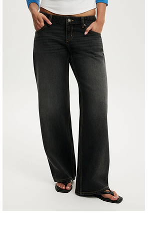 Woman wearing black wide-leg jeans with a white top and black sandals