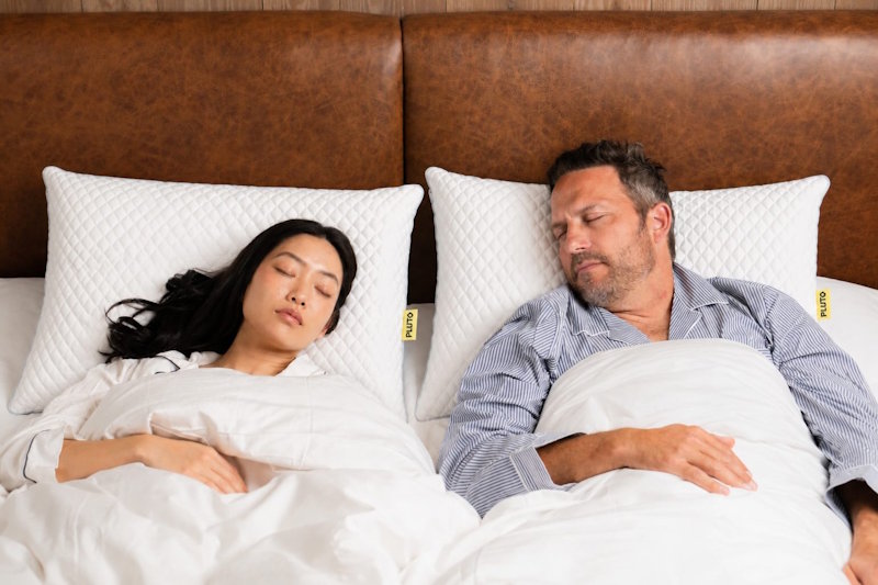 a man and woman sleeping in bed