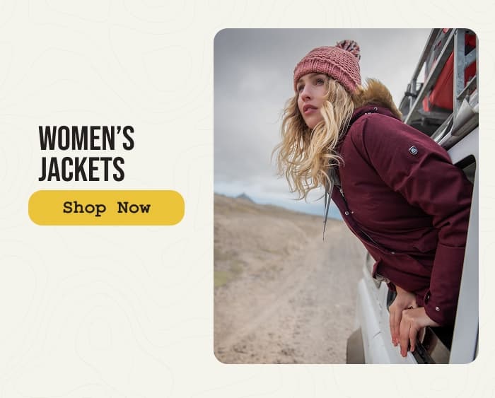 Photo of a woman wearing a Craghoppers insulated jacket with the wind blowing her hair. CTA: Women's jackets, shop now.