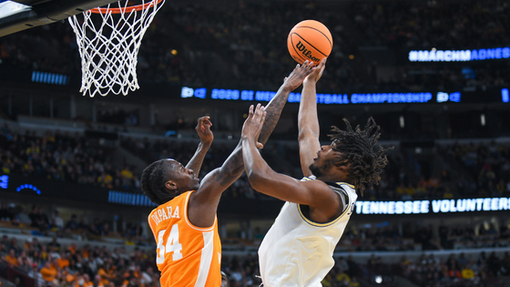 Two basketball players jump for the ball.