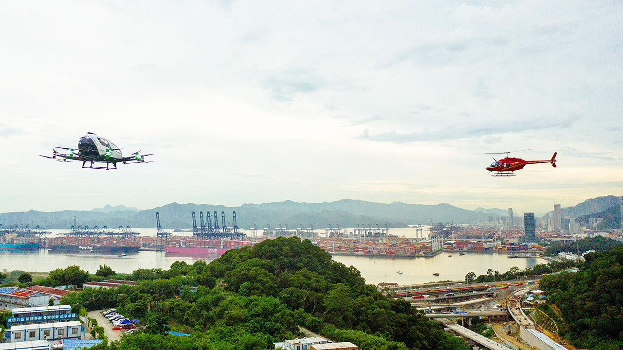A helicopter and a passenger-grade autonomous aerial vehicle fly above Shenzhen, China