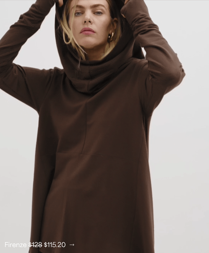 Close-up of Maritza in The Firenze Hoodie with a draped cowl hood, resting her chin on her hand.
