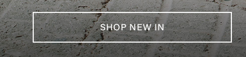 Prominently displayed 'SHOP NEW IN' button with white text and border, set against a rugged dark gray concrete background, encouraging discovery of new arrivals.