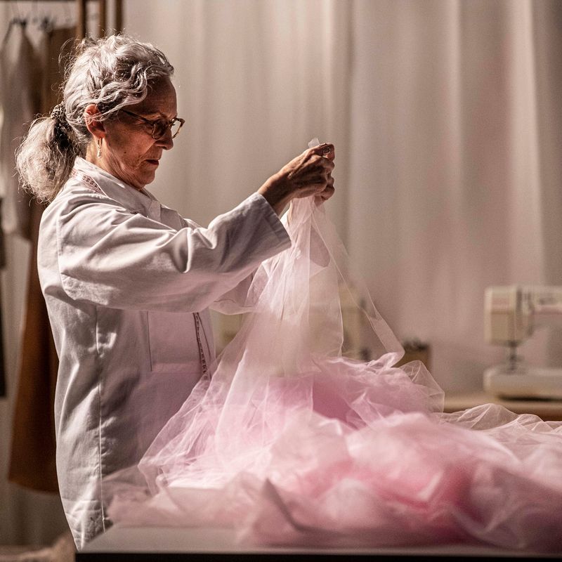 Person holding up pink fabric.