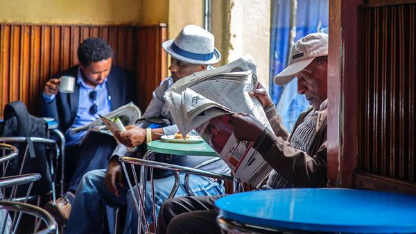 Ethiopian men read newspapers and drink coffee at a cafe in Addis Ababa