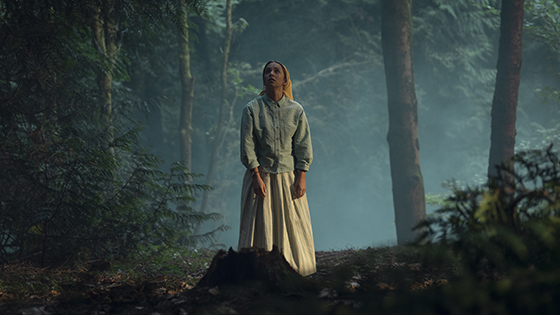 A woman standing in the woods.