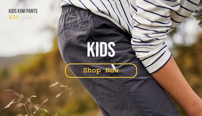Lifestyle photo of a kid wearing Kiwi Pants while playing in a field.