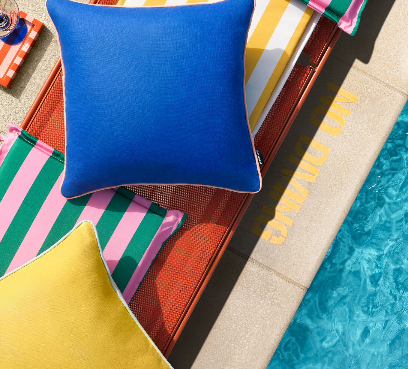 Colourful pillow stacked by the poolside