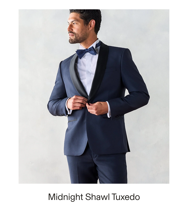 Male model wearing a navy blue Midnight Shawl Tuxedo with black shawl lapels, a white dress shirt, and a navy bow tie. Text reads: "Midnight Shawl Tuxedo"