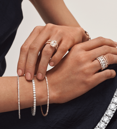 Female model wearing diamond rings and tennis bracelets in white and yellow gold.