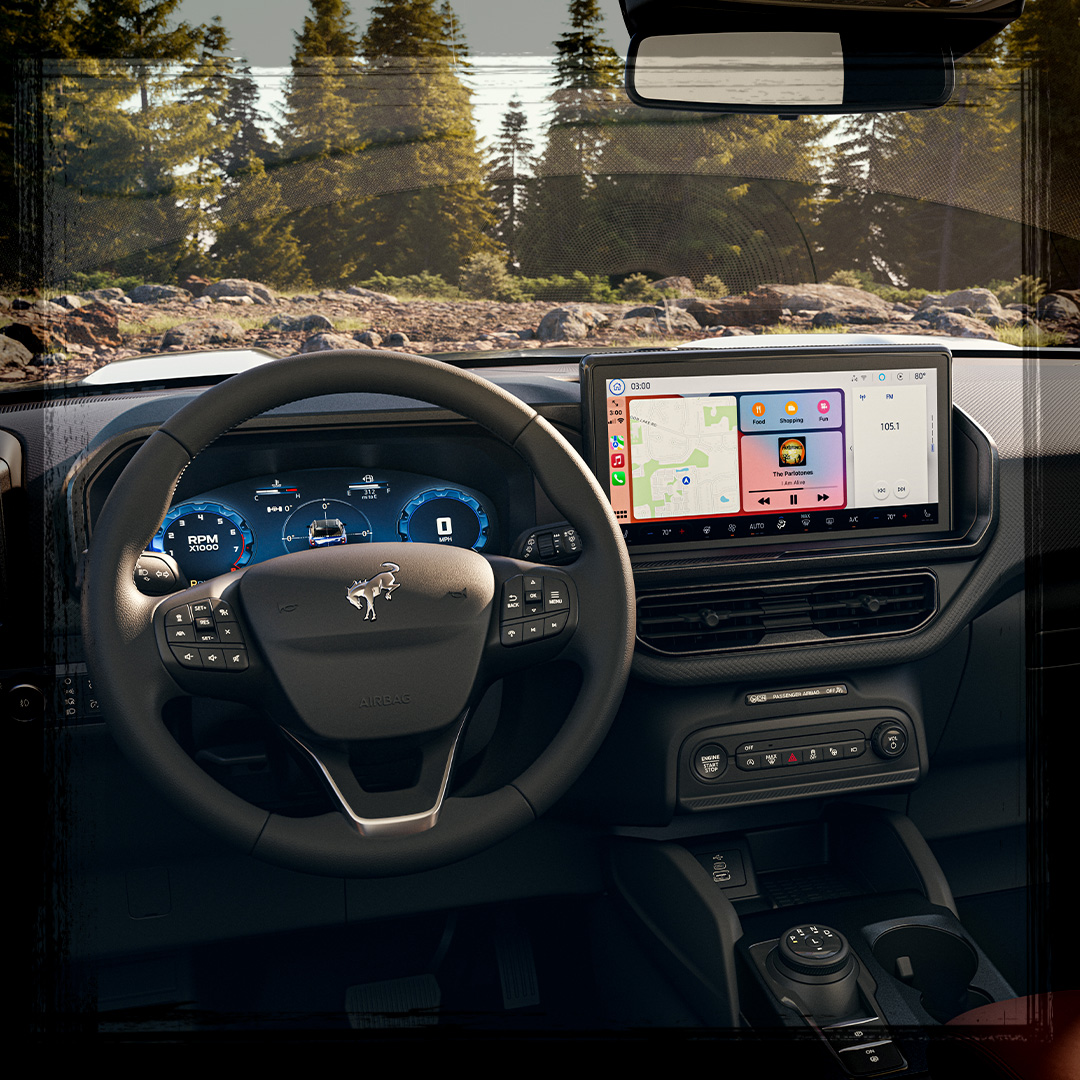 The front cabin of a Ford Bronco Sport&reg; SUV with a forest visible through the front windshield