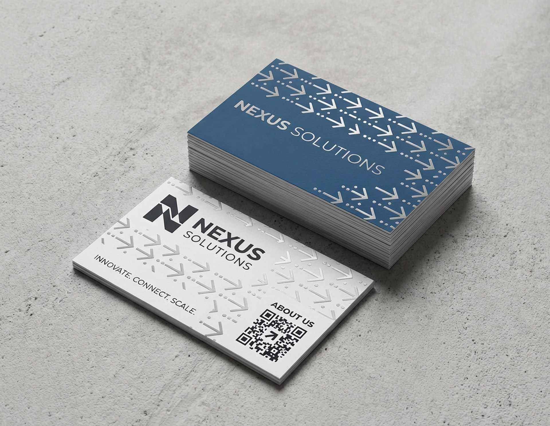 Stack of Nexus Solutions business cards with blue and white design, repeating arrow pattern, and QR code.