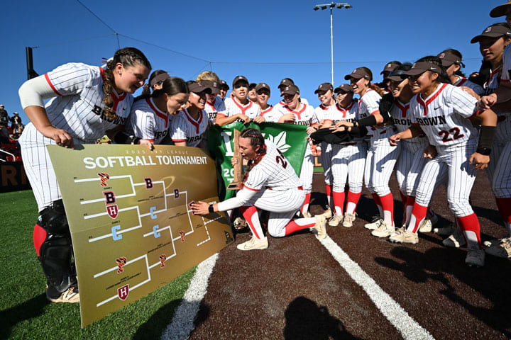 softball team admires a bracket