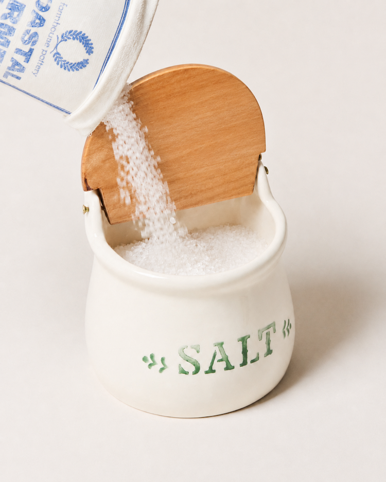The Cottage Salt Cellar with its flip-top lid open beside the stove