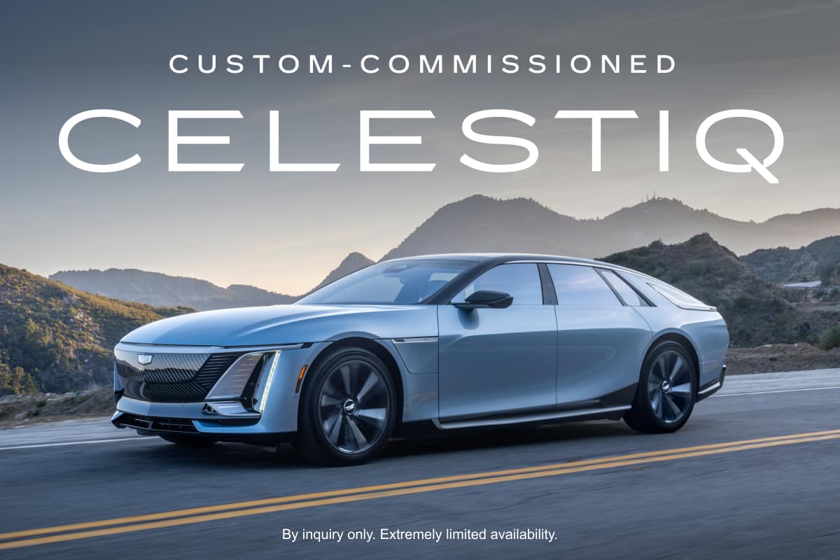 Custom-comissioned CELESTIQ. By inquiry only. Extremely limited availability. Side angle shot of a silver Cadillac CELESTIQ driving along a winding road through a mountainous landscape. 