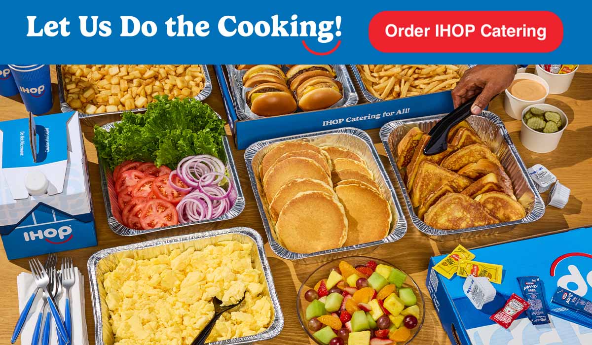 A full IHOP Catering spread, with tons of pancakes, french toast, scrambled eggs, and more.