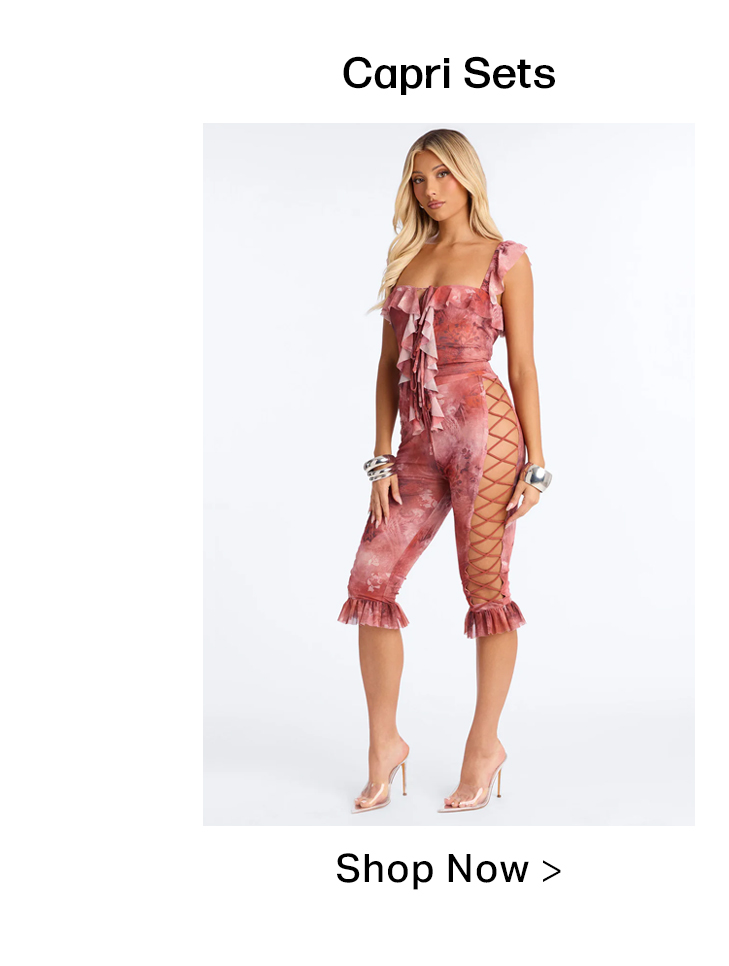 Woman models a fashionable pink and rust tie-dye capri set with a ruffled top, lace-up sides, and ruffled cuffs. Shop our Capri Sets!