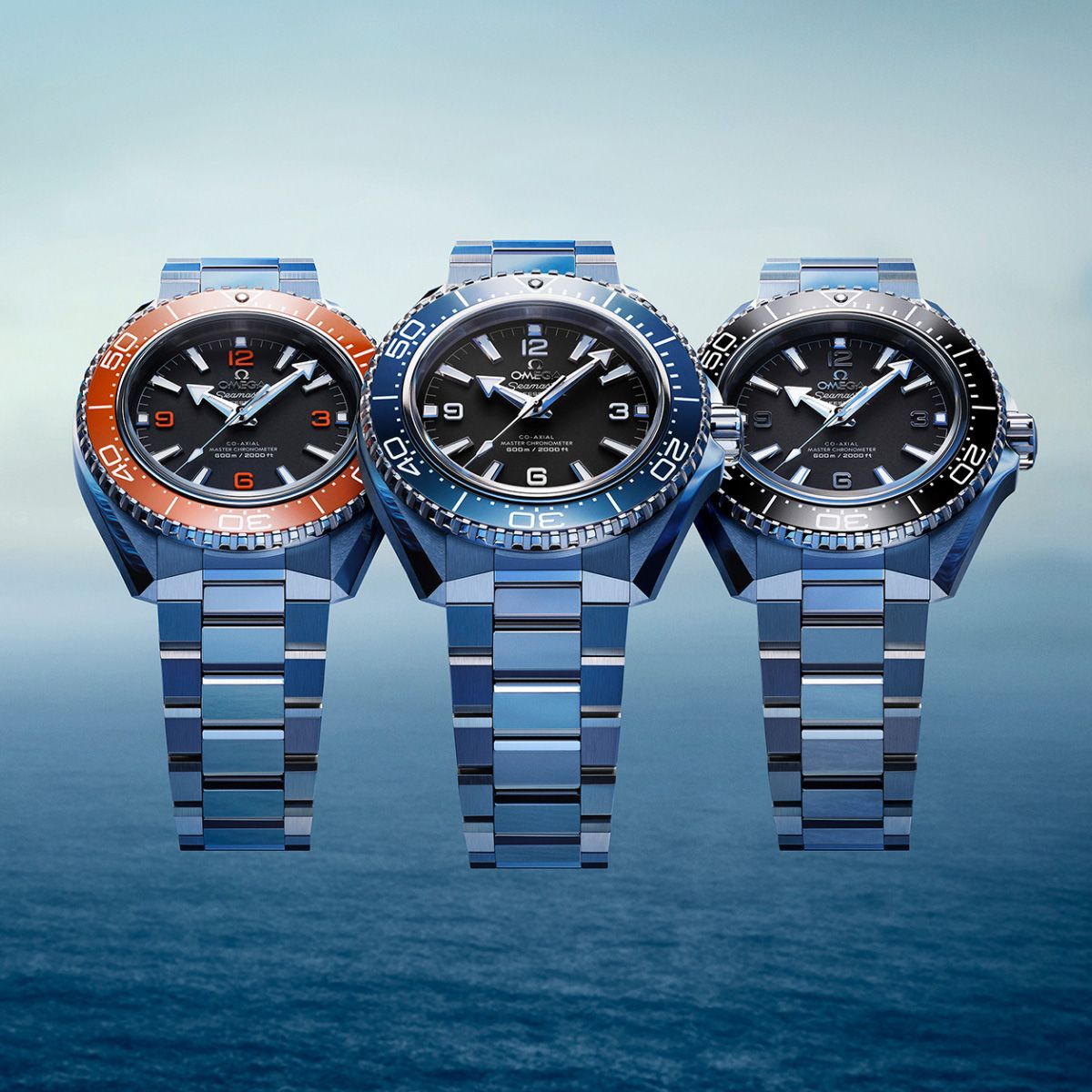 Three Omega seamaster planet ocean watches in front of an ocean backdrop