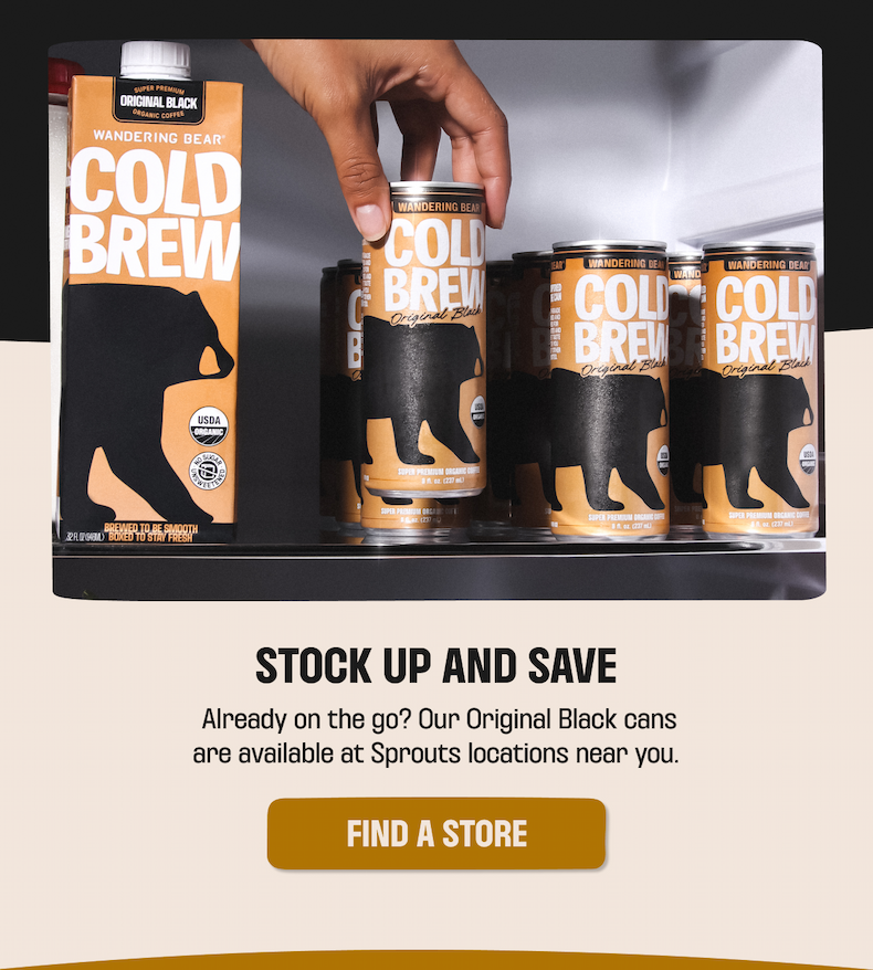 Hand grabbing a Wandering Bear Cold Brew Original Black can from a fridge stocked with cans and cartons — find a store near you